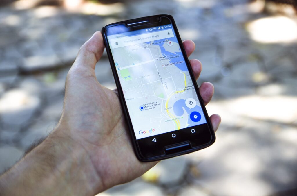 地図アプリを開いたスマホを手に持って、近くのお店を探している様子